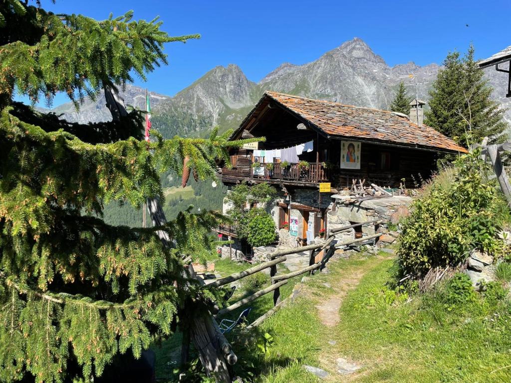a house on a hill with mountains in the background at Rifugio Guide Frachey in Saint Jacques