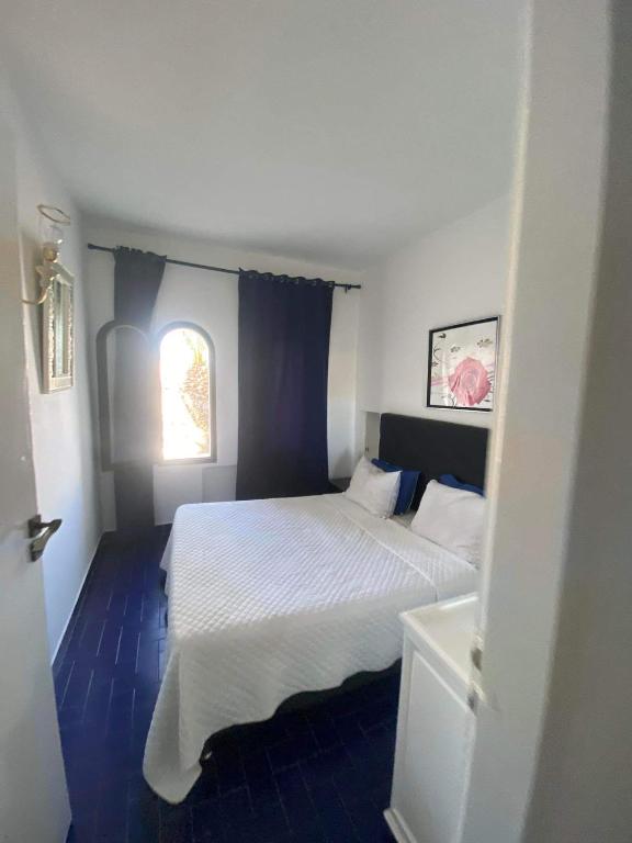 um quarto com uma cama branca e uma janela em Port kantaoui em Tunes