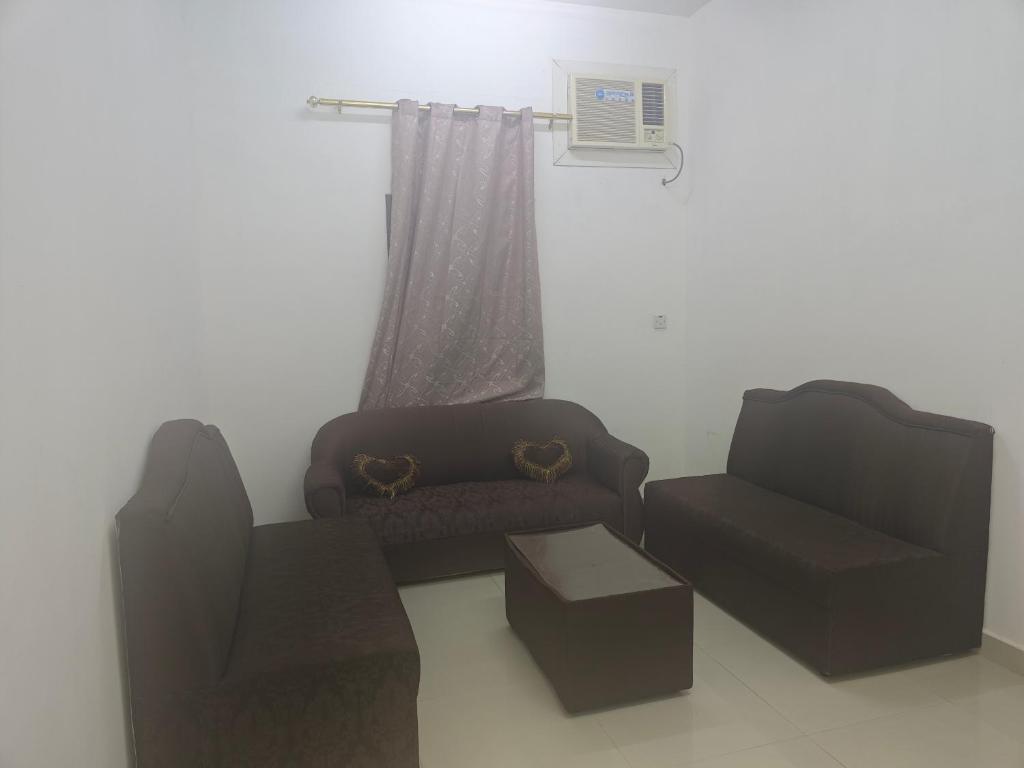 sala de estar con 2 sillas y sofá en شقق وادي ذنه, en Salalah