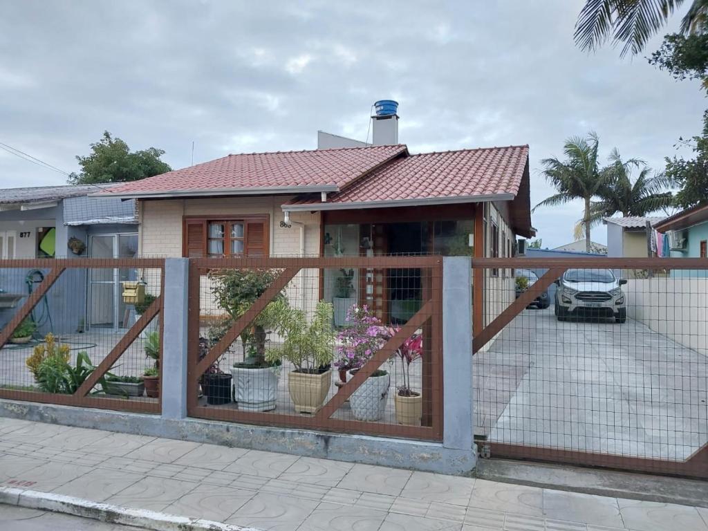 a house with a wooden fence in front of it at Casa em Torres Praia da Cal in Torres