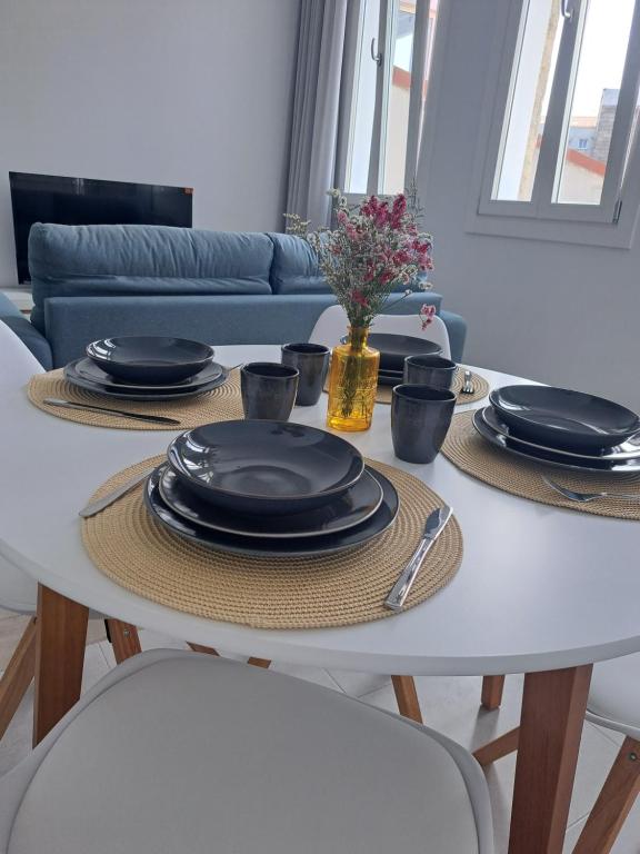 a white table with plates and dishes on it at Loft Turístico Bouzas in Vigo