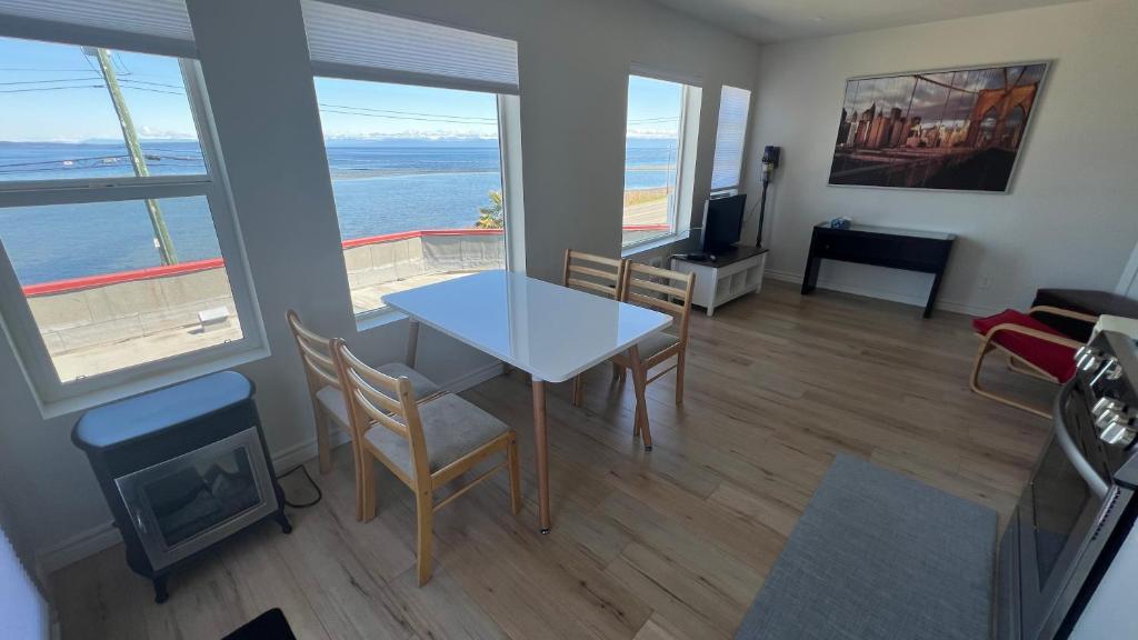 een woonkamer met een tafel en uitzicht op de oceaan bij Penthouse in Bowser