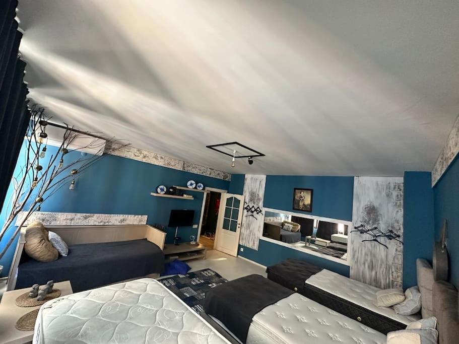 a bedroom with two beds and a blue wall at Luxury House City Center in Trabzon