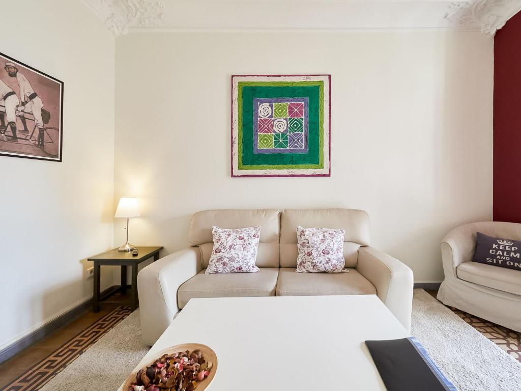a living room with a couch and a table at Belvilla by OYO Rambla Paris Apartment in Barcelona