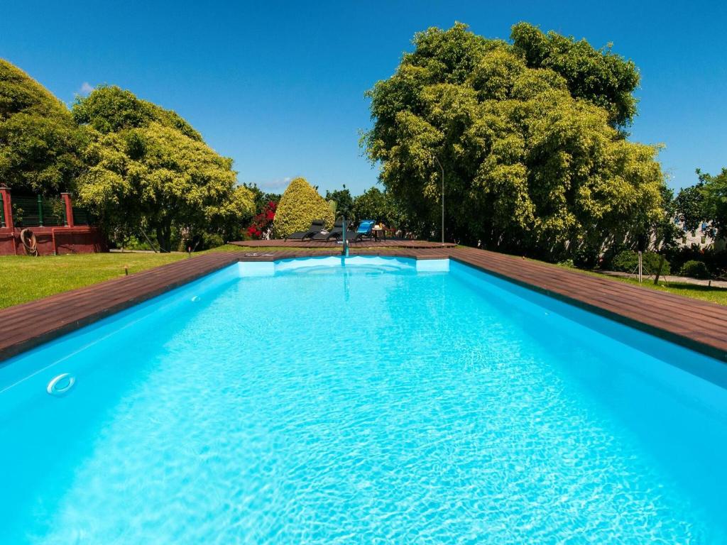 a blue swimming pool with trees in the background at beautiful 5 bedroom property with sea view, private tennis court private pool in Arucas