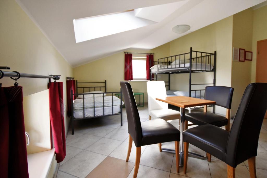 Camera con tavolo, sedie e letti a castello. di Hostel X Point a Kobarid
