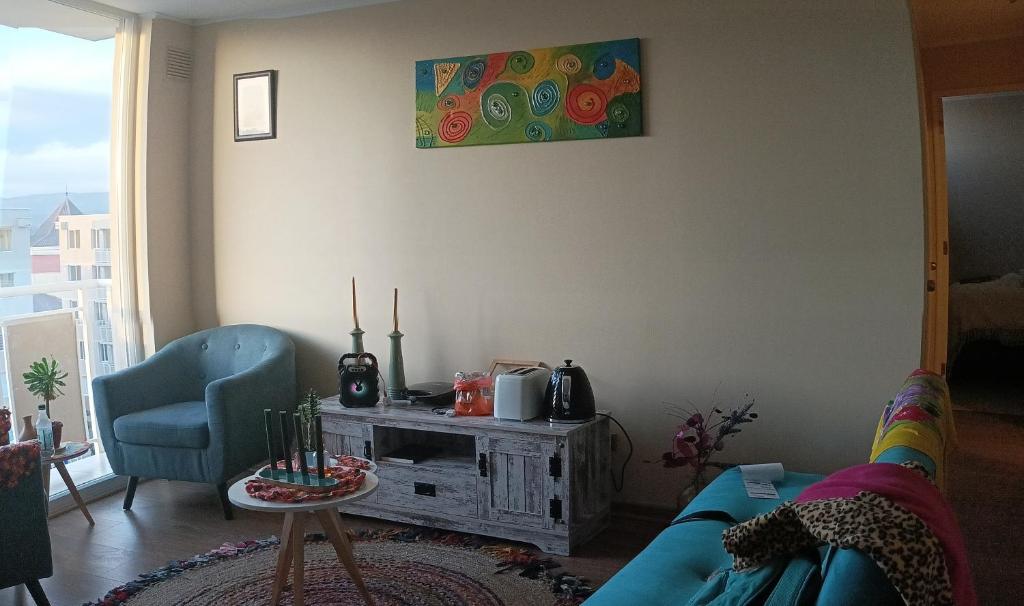 a living room with a blue couch and a table at LODGING DAy in Temuco