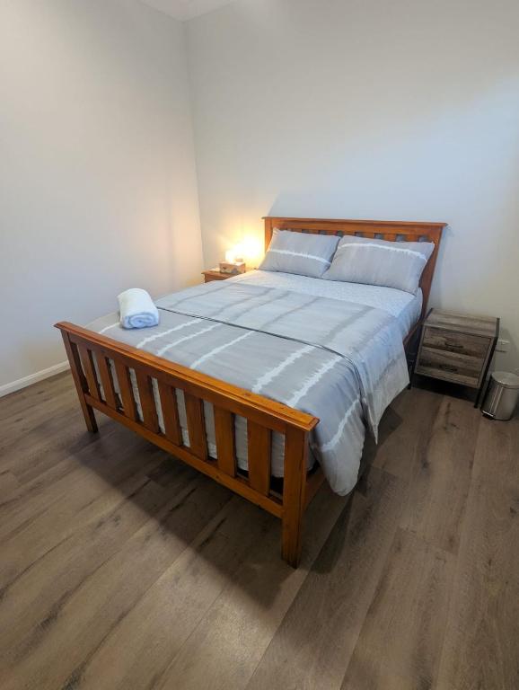 a large bed with a wooden frame in a bedroom at Immaculate 2-Beds Entire House Chermside Brisbane in Brisbane