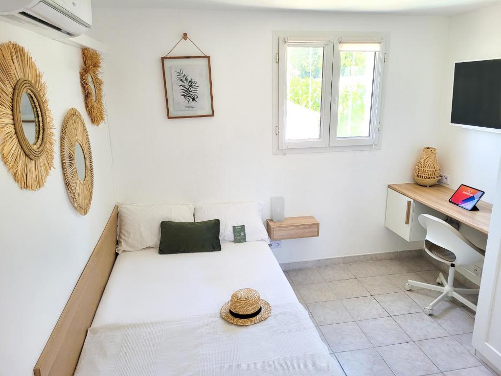 a bedroom with a bed and a desk and a window at Appartement double climatisé - Proche Tram & Centre in Montpellier