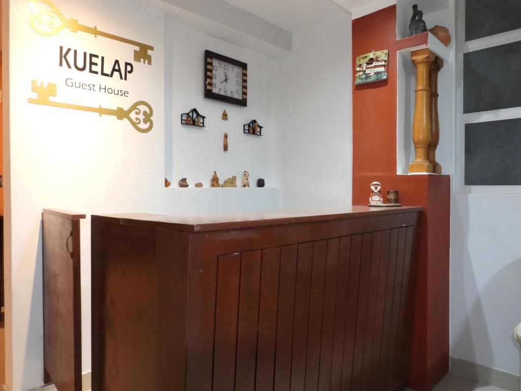 チャチャポヤスにあるKuelap Guest Houseの木製のドアと壁に看板が付いた部屋