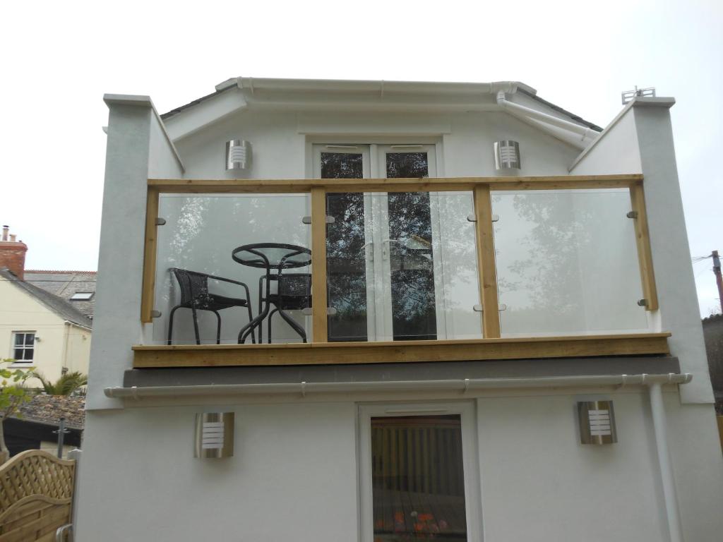 a house with a balcony with a table on it at Meander in Penzance