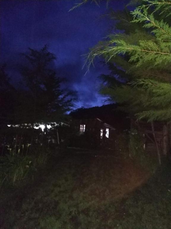 een nachtelijke foto van een huis in een tuin bij LA RIVIERA Posada Campestre in Bolívar