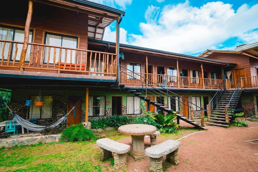 a house with a table and benches in front of it at Pension Santa Elena in Monteverde Costa Rica