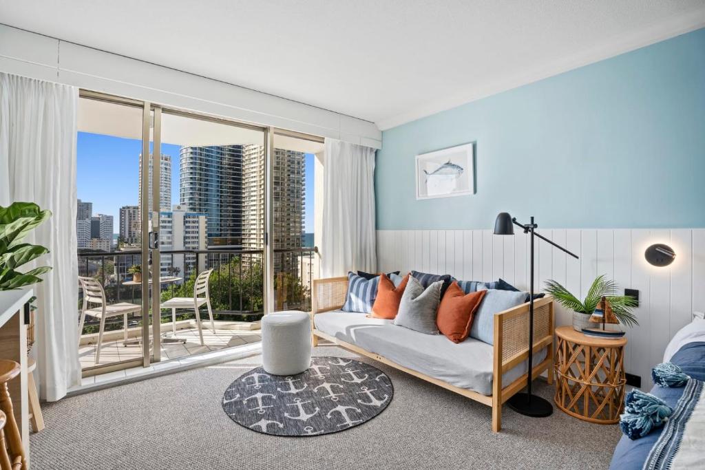 a living room with a couch and a large window at Mantra View Studio Surfers Paradise Walk To Beach in Gold Coast