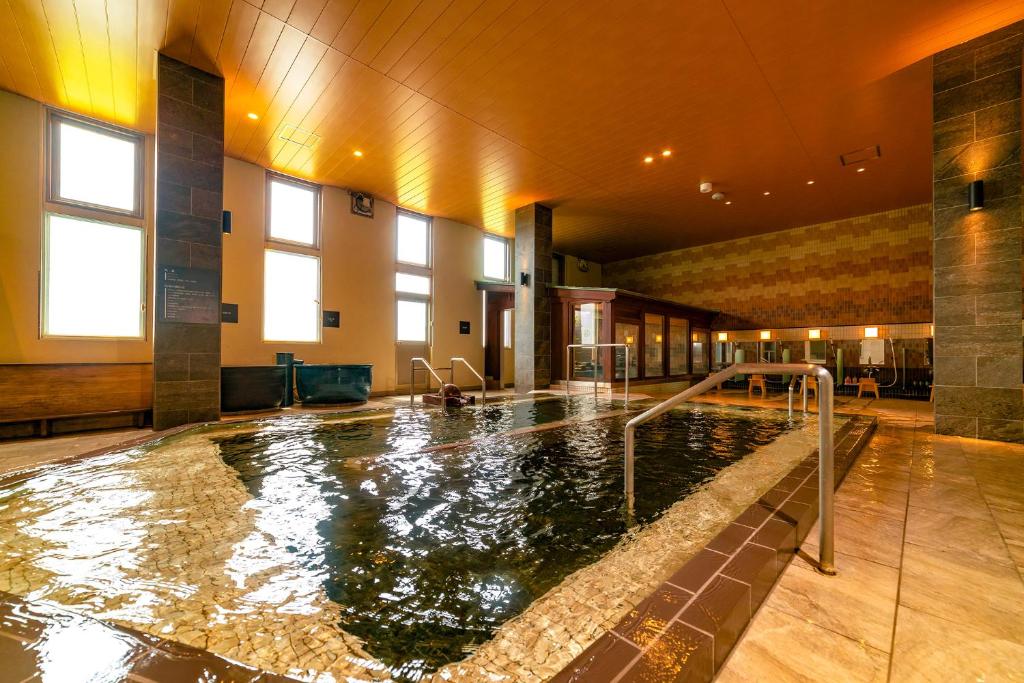 einem großen Innenpool in einem Gebäude in der Unterkunft Ooedo Onsen Monogatari Premium Kinosaki in Toyooka