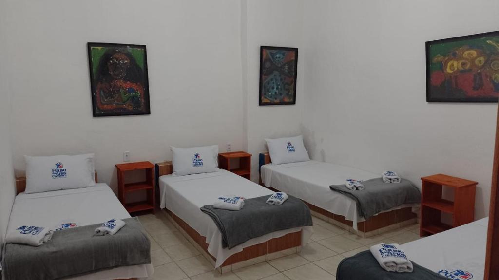 um quarto com quatro camas num quarto em Pouso das Artes Cachoeira-hospedaria e espaço cultural em Campinas