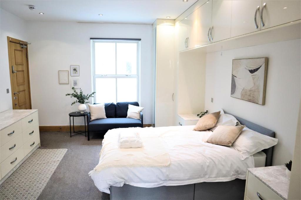 a bedroom with a large white bed and a chair at Camden, London, Holloway Rooms in London
