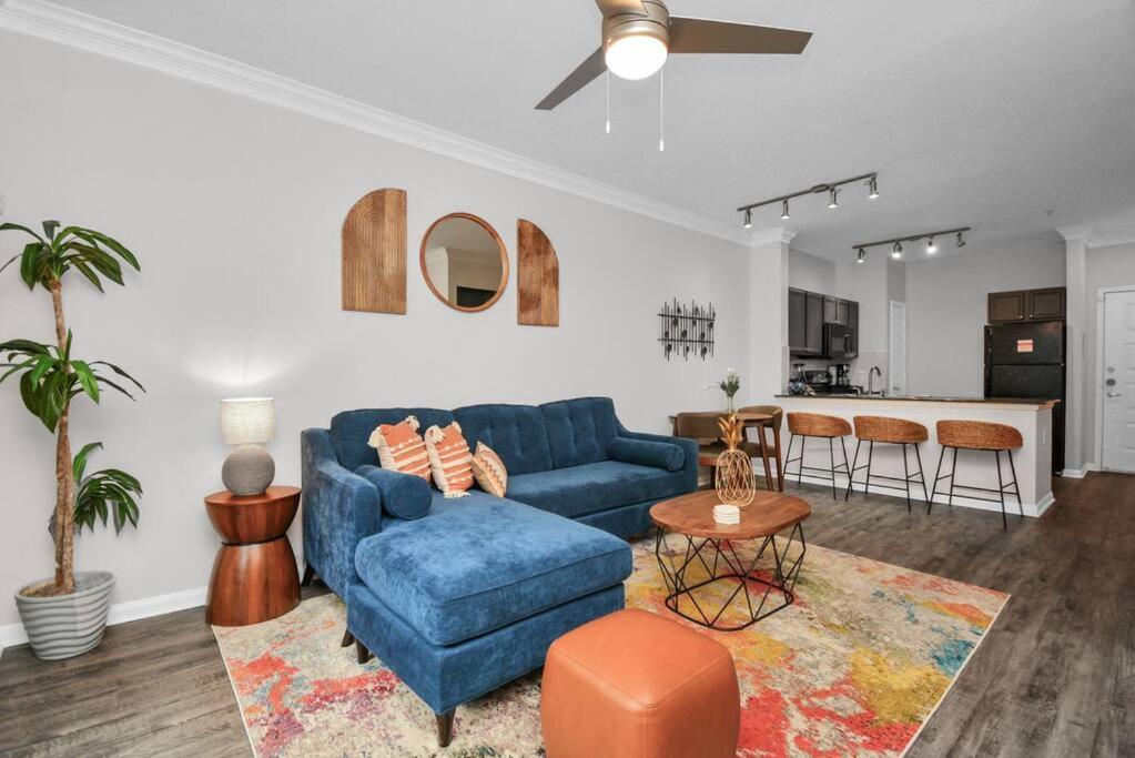 Il comprend un salon avec un canapé bleu et une cuisine. dans l'établissement The Bohemian Escape near Rice Village in Houston!, à Houston