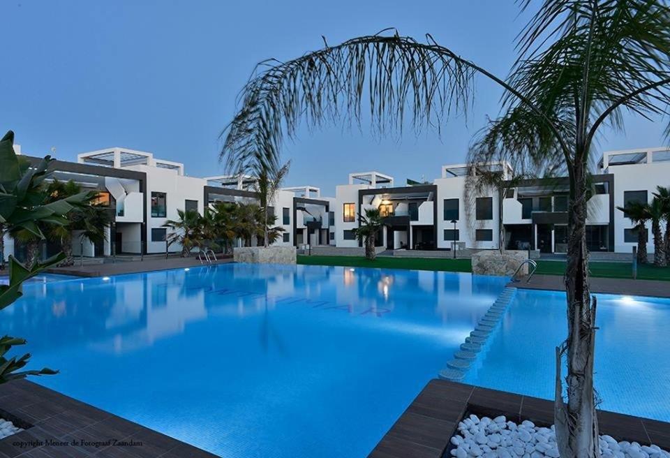 una grande piscina di fronte ad alcuni edifici di Penthouse Oasis Beach La Zenia a Playas de Orihuela