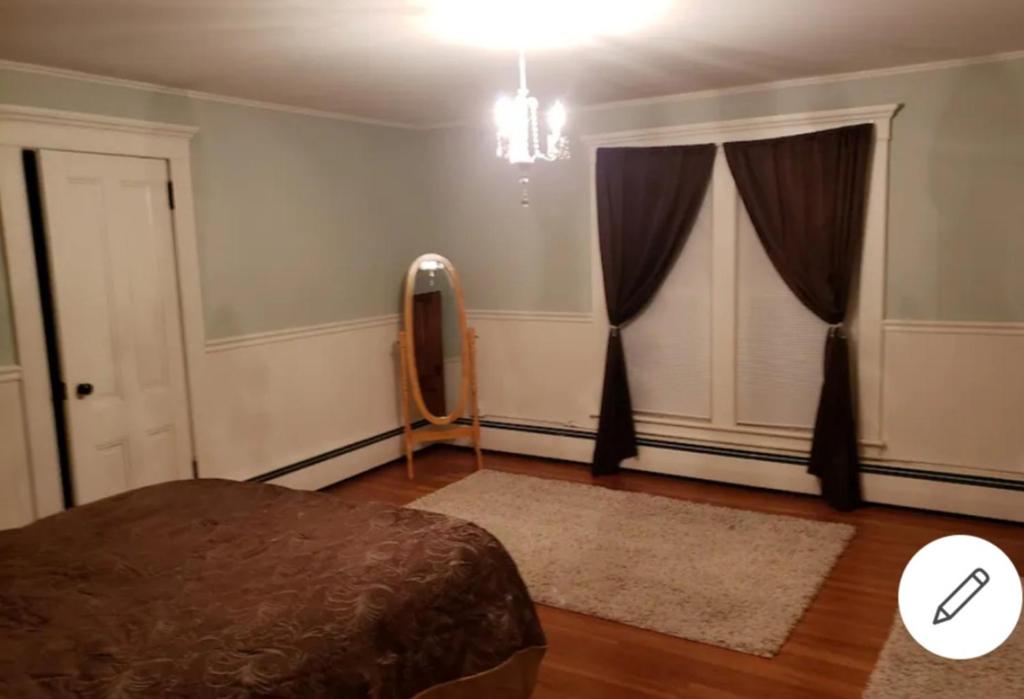 a bedroom with a bed and a chandelier at Cummings Place AirBNB in Wellsville