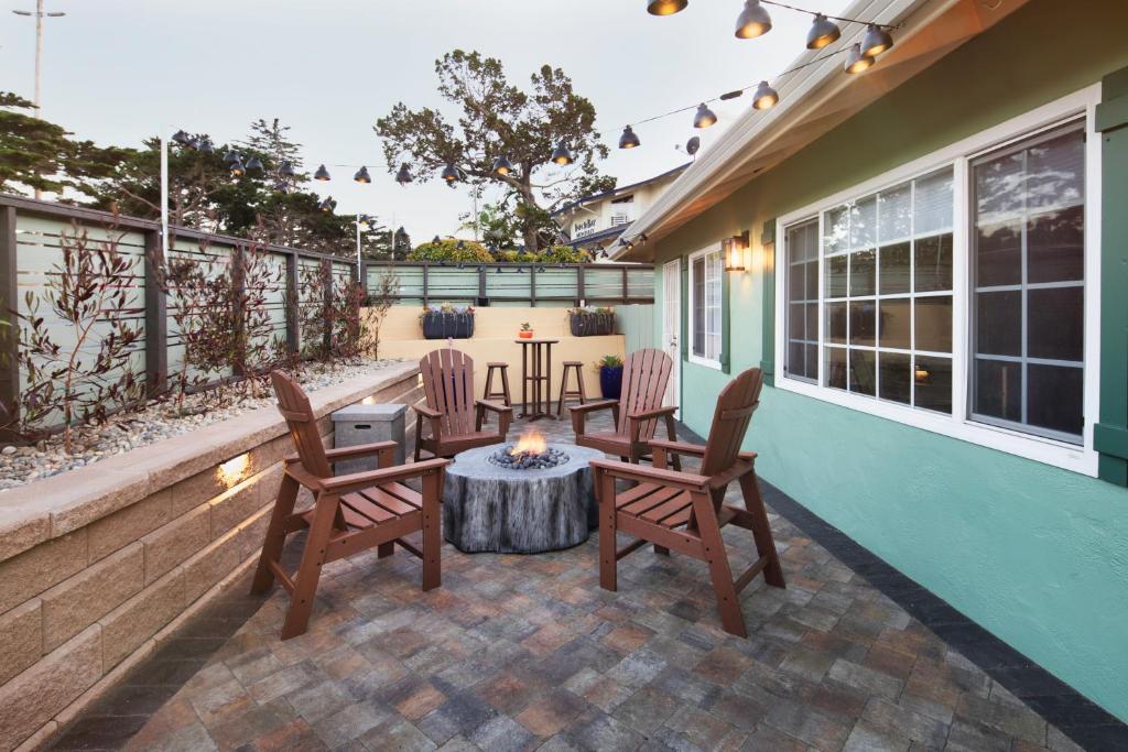 a patio with chairs and a table and a fire pit at Villa Franca Inn in Monterey