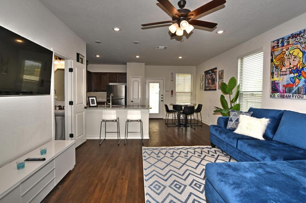 ein Wohnzimmer mit einem blauen Sofa und einer Küche in der Unterkunft New 3 Bedroom Vacation Home Lackland/Sea World/La Cantera in San Antonio