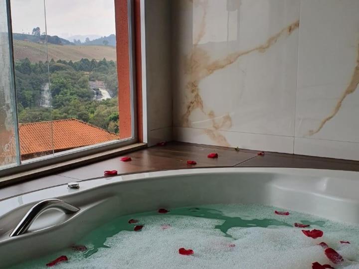 a bathroom with a bath tub with roses on the floor at Cachoeira dos Luis - Parque & Pousada in Bueno Brandão