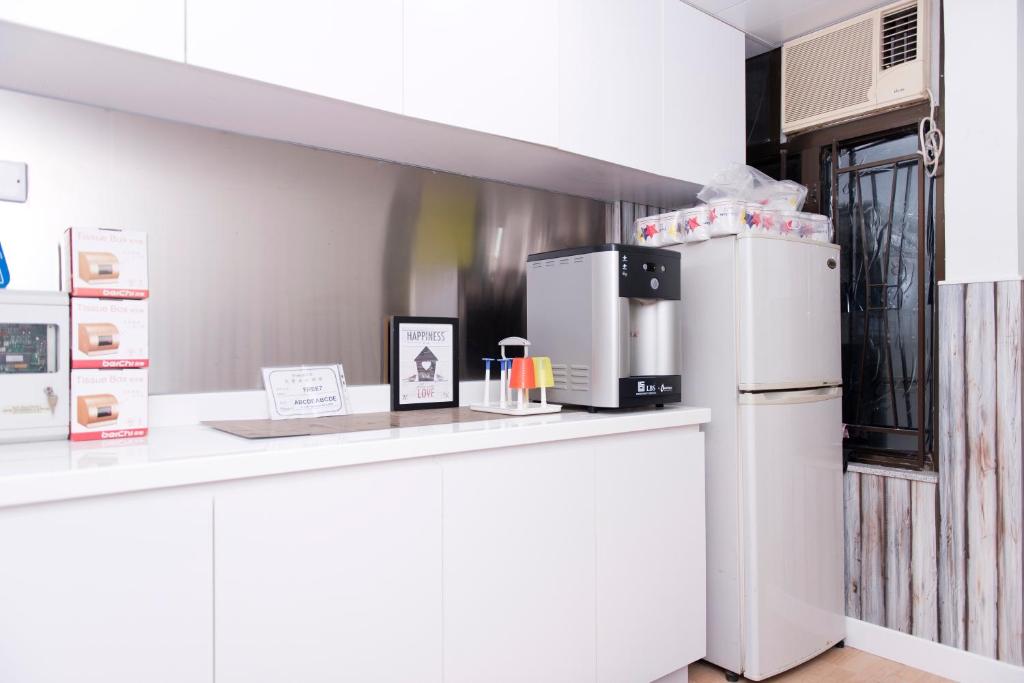 uma cozinha com um balcão branco e um frigorífico em Ah Shan Hostel em Hong Kong