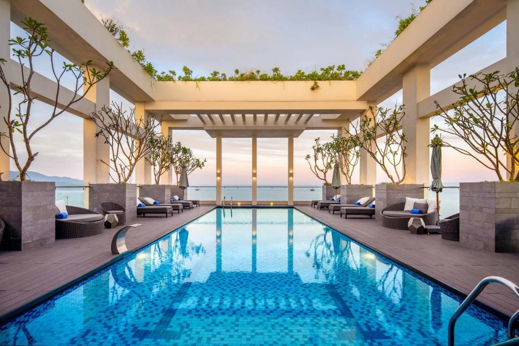 a pool at a hotel with chairs and a view at Paris Deli Danang Beach Hotel in Danang