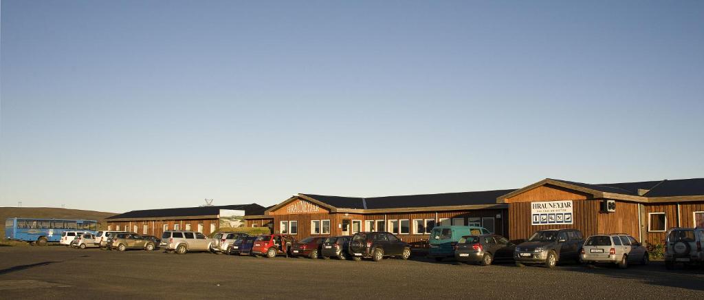 un estacionamiento con autos estacionados frente a un edificio en The Highland Center Hrauneyjar en Sprengisandur