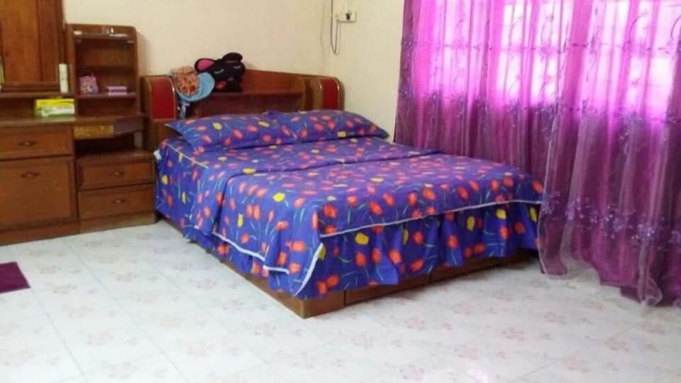 um quarto com uma cama com uma cortina roxa em Homestay Tambun Ipoh em Tambun