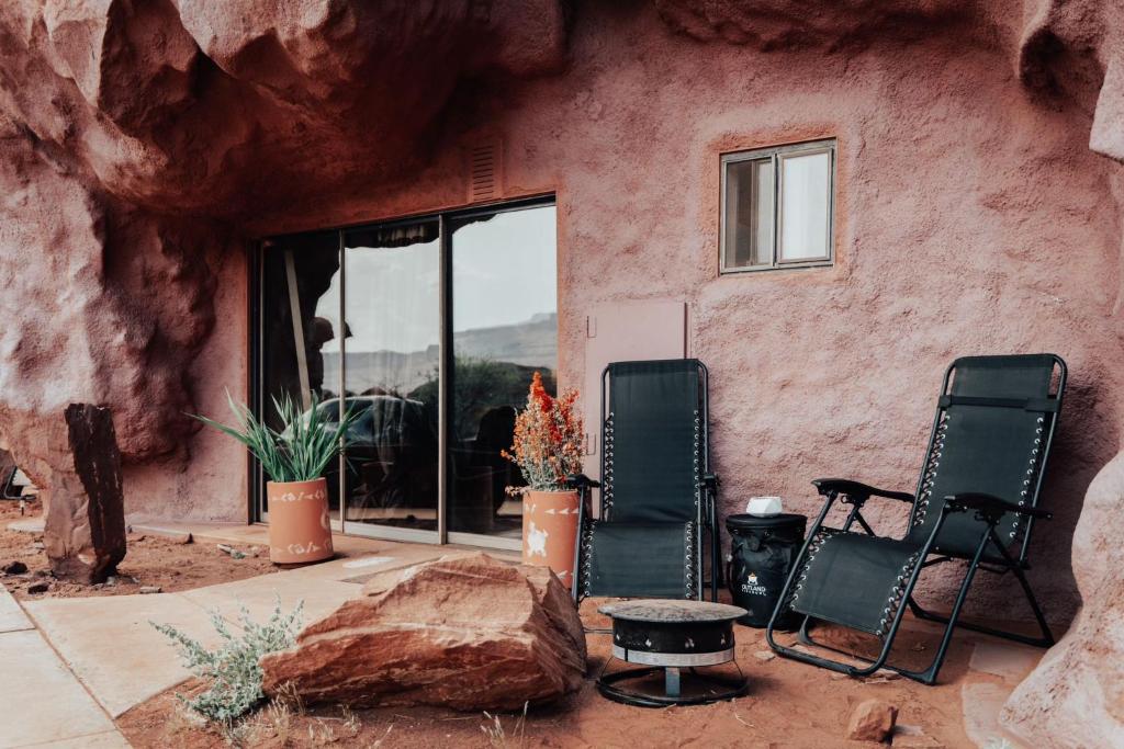 two chairs and a table in front of a building at Redrock Riverside Cave 3 - Glamping Cave Suite in Moab