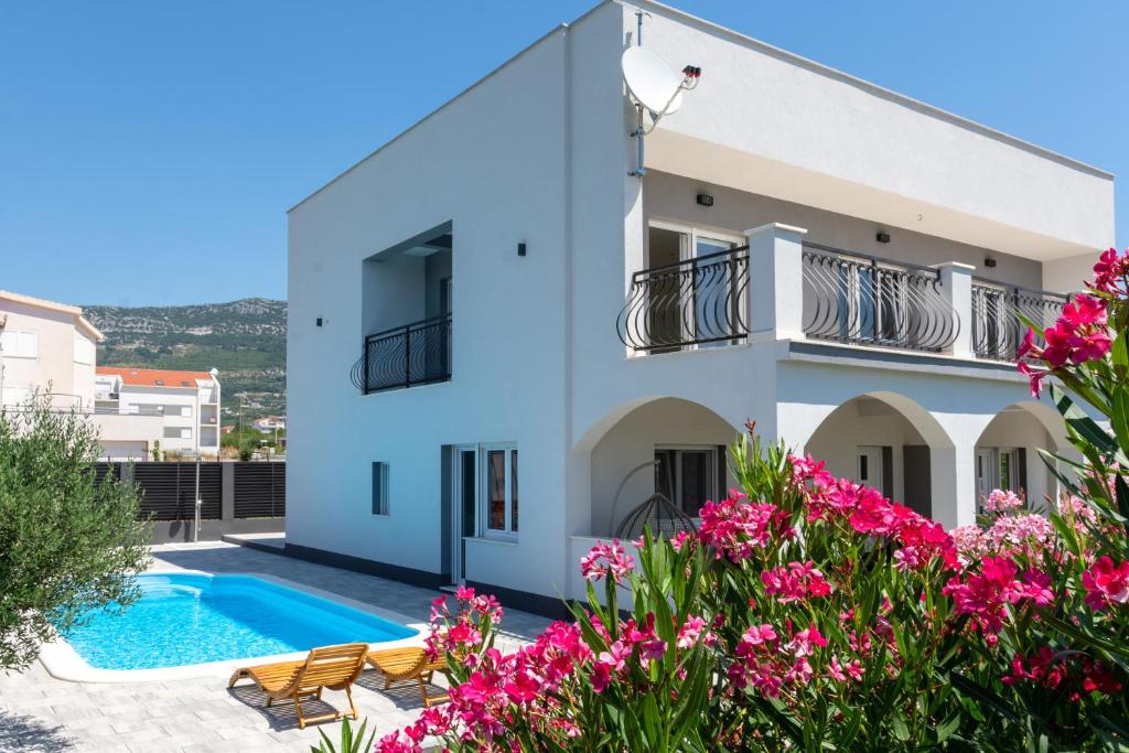 eine Villa mit einem Pool und Blumen in der Unterkunft Villa Kalani in Kaštela