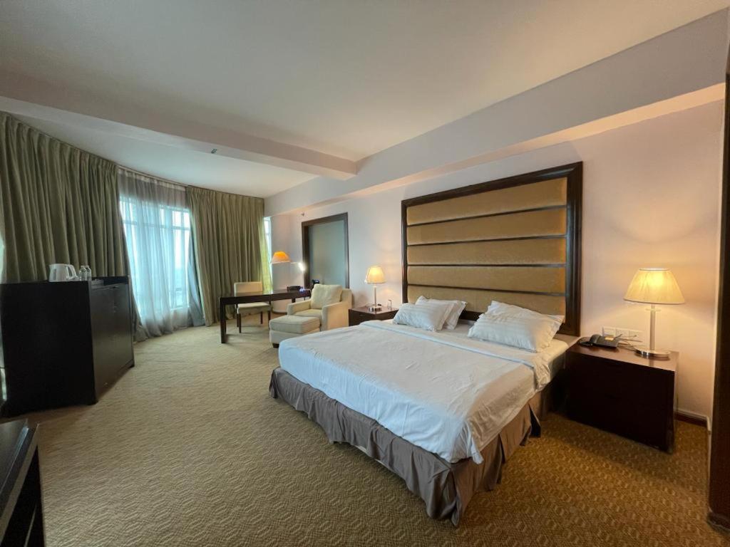 una camera d'albergo con un grande letto e una TV di Oriental Crystal Hotel a Kajang