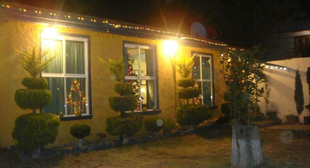 a house with christmas lights on the windows at night at Casa Chak in Mexico City