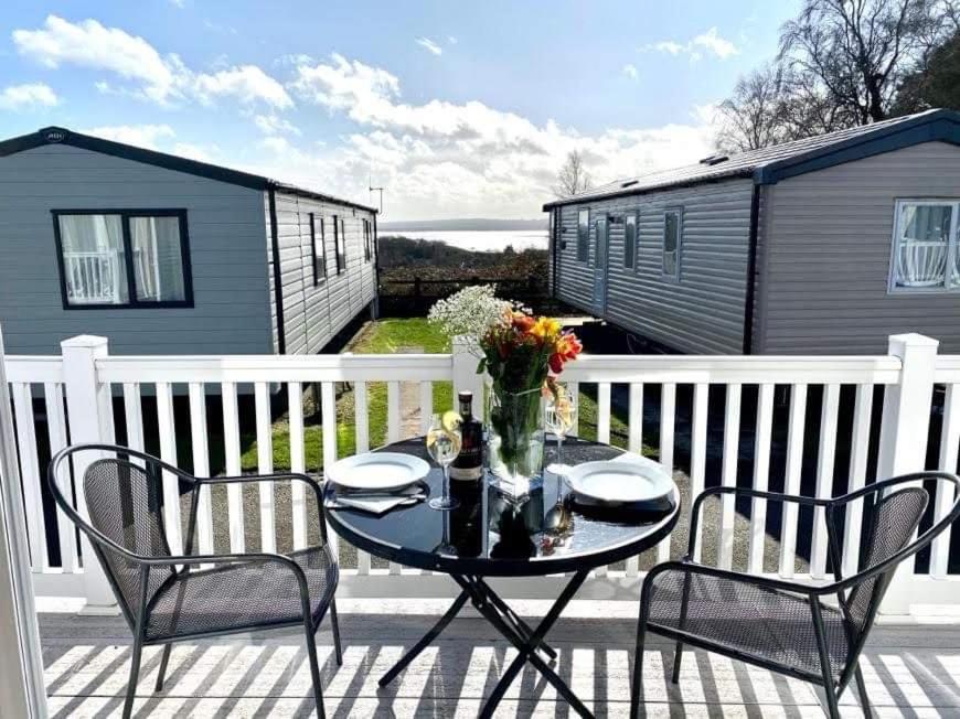 a patio with a table and two chairs on a deck at Rockley Park, Arne View in Hamworthy