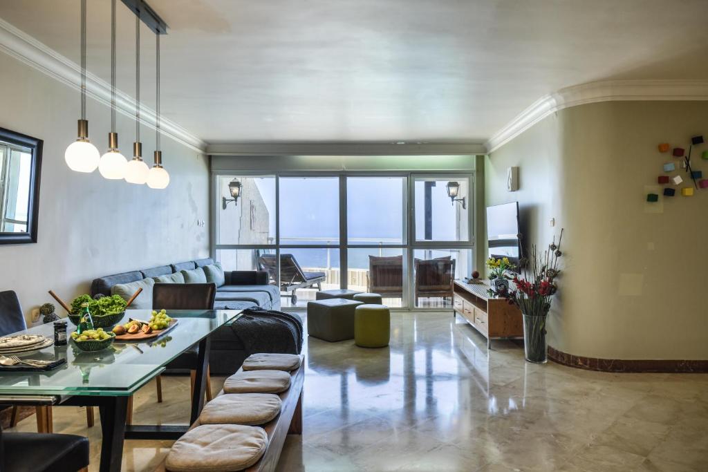a living room with a couch and a table at Netanya Panoramic Sea-View Apt by Sea N' Rent in Netanya