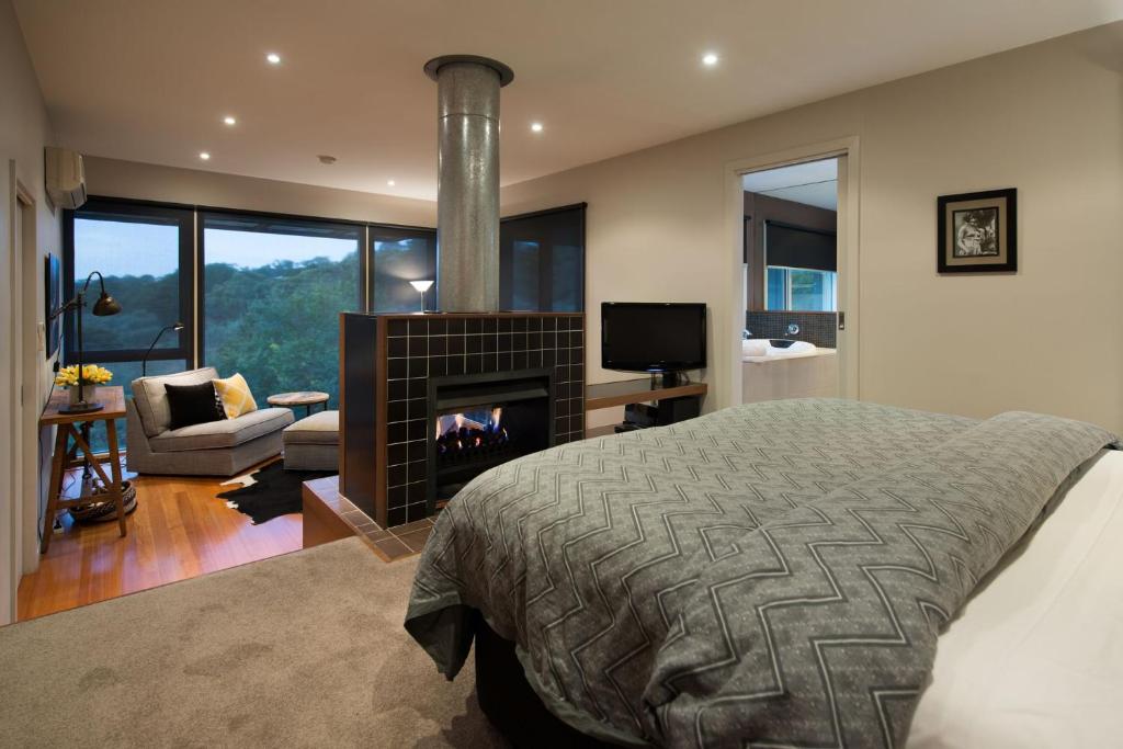 a bedroom with a fireplace and a bed and a couch at Daylesford Spa Villa 4 in Daylesford