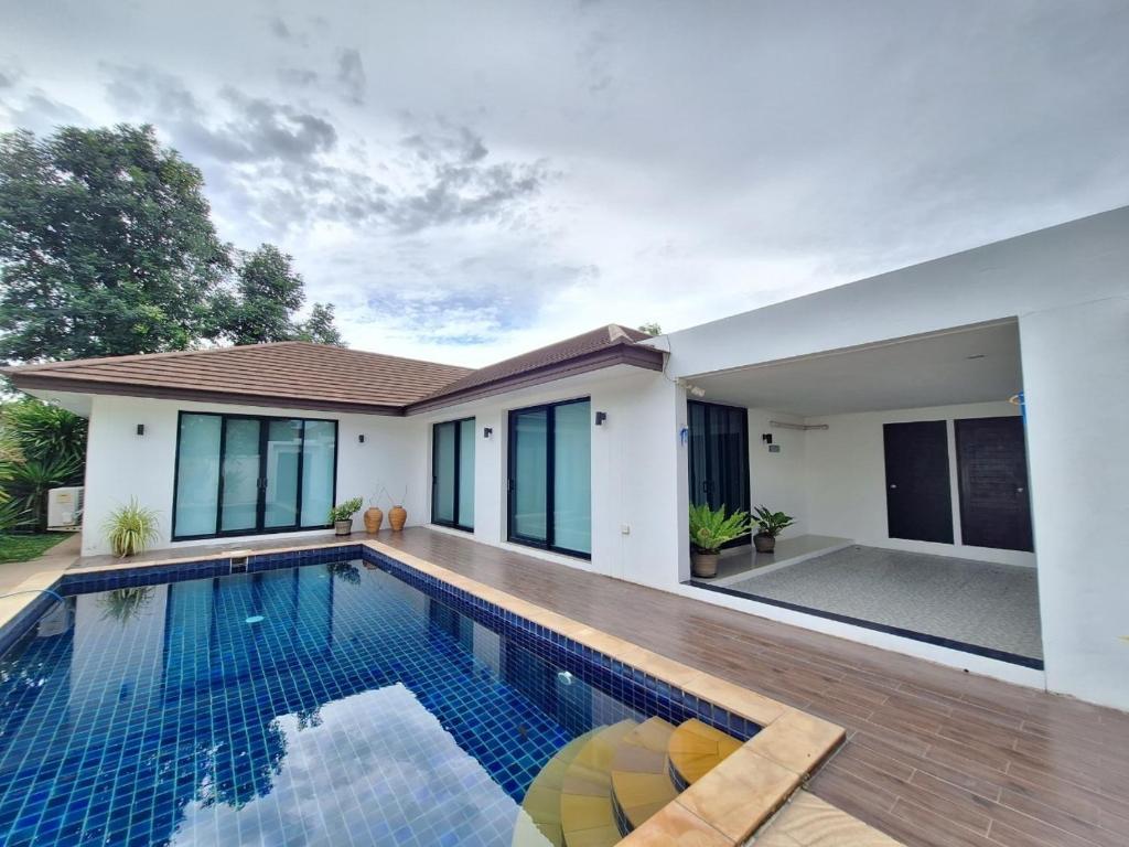 a swimming pool in front of a house at Pool Villa 3bedroom Bann Anda by fantaseabeachpattaya in Nong Prue