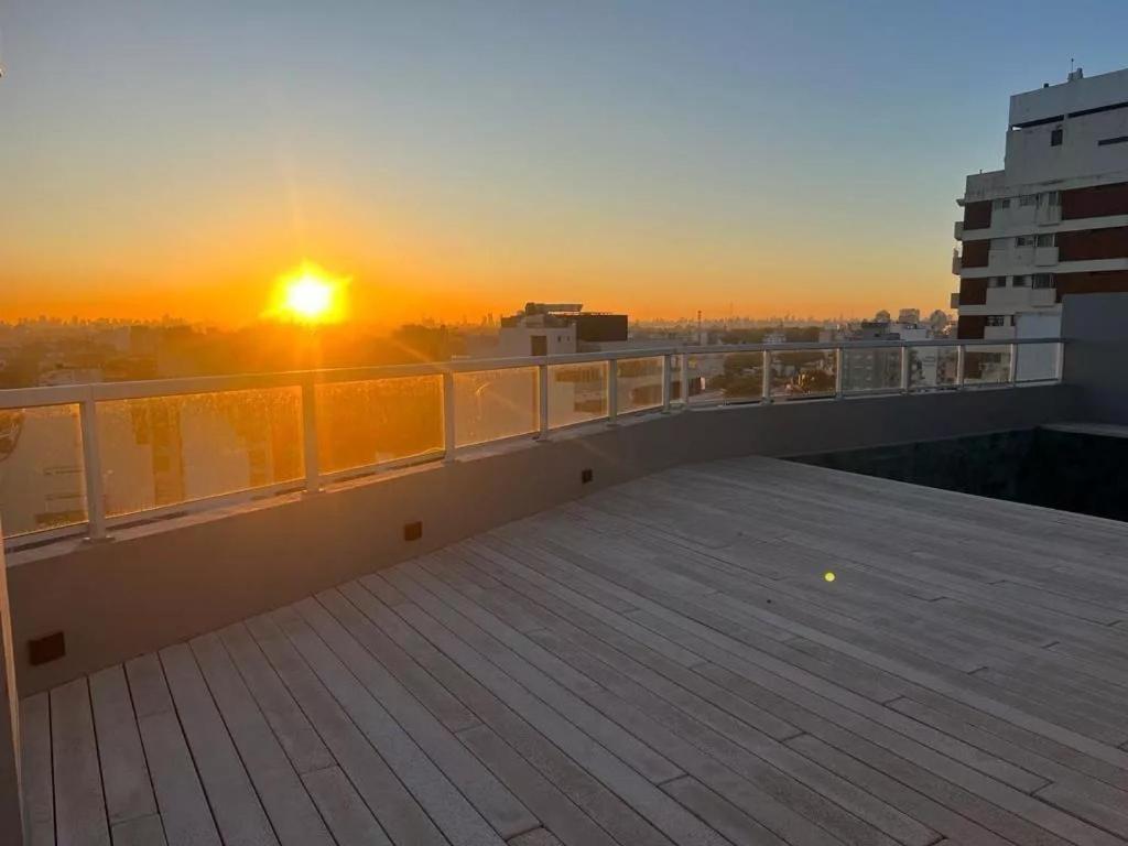 ブエノスアイレスにあるPenthouse a estrenar en Sofisticado Barrio y Edificio Vista panorámica 100m2 Gimnasio Piscina Lujoso Salon de Fiestas Parking privado con acceso directo al departamentoの建物のバルコニーから夕日を望めます。