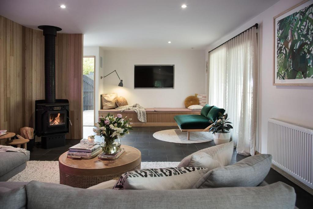 a living room with a couch and a fireplace at Dollywood in Daylesford