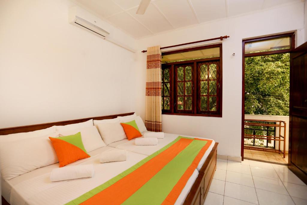 Citrus Cafe & Restaurant في كاندي: غرفة بها سرير وبطانية ملونة