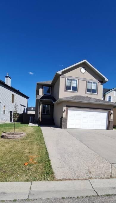 a large house with a garage on a street at Spacious comfortable Air-Conditioned. Near airport! in Calgary