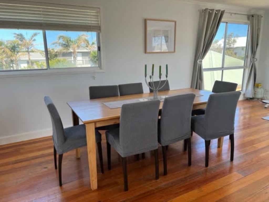 a dining room with a wooden table and chairs at Sinclair Surfside Stay in Surf Beach