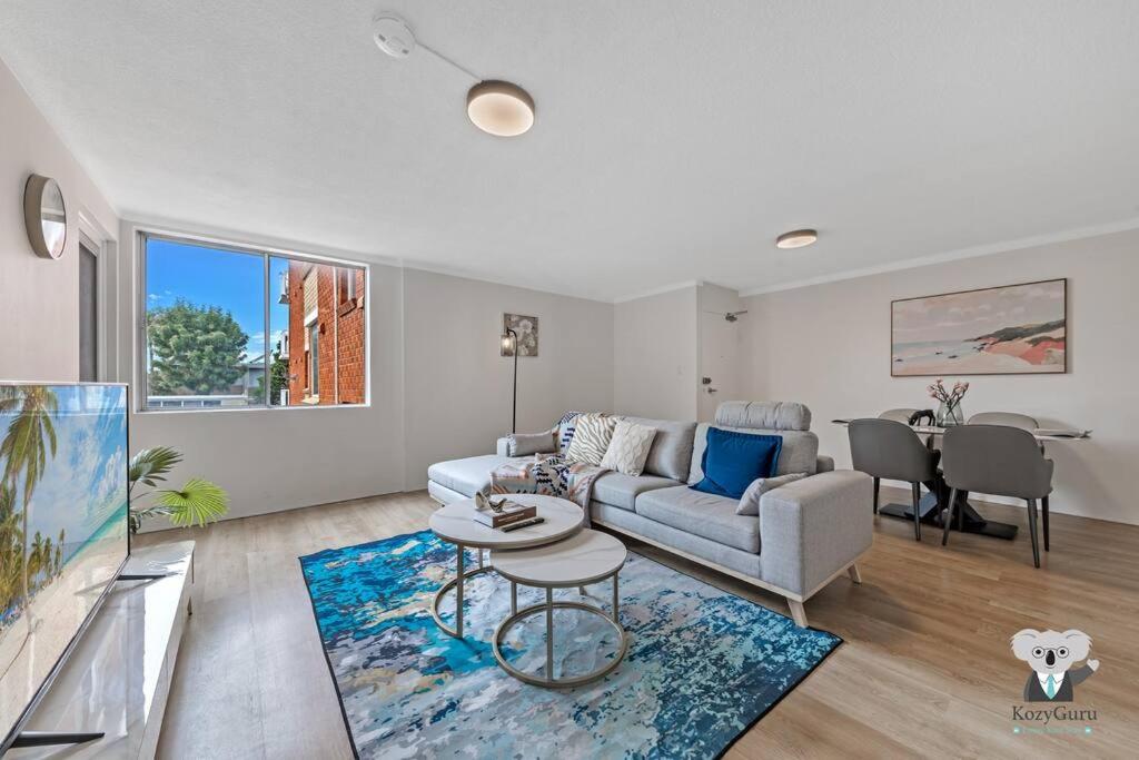 uma sala de estar com um sofá e uma mesa em KozyGuru / Clovelly / 2B Kozy APT / NCL037 em Sydney