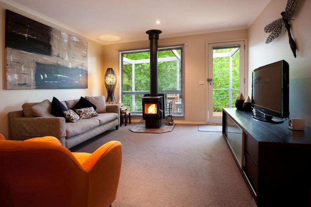 a living room with a couch and a fireplace at Eastern View Villa in Daylesford
