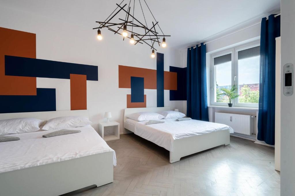 1 dormitorio con 2 camas y un cuadro en la pared en Blue Apartment Browar Central, en Poznan
