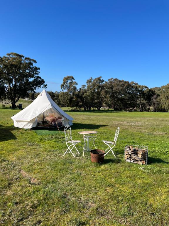 a tent with a table and chairs in a field at Cosy Glamping Tent 2 in Ararat