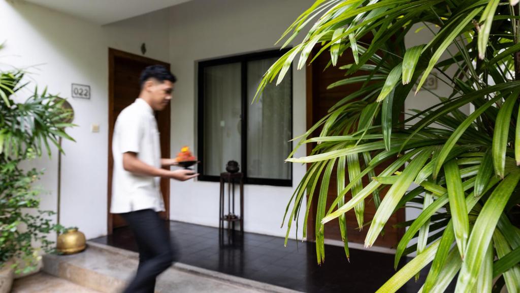 a man walking out of a house at Lynnaya Urban River Resort in Siem Reap