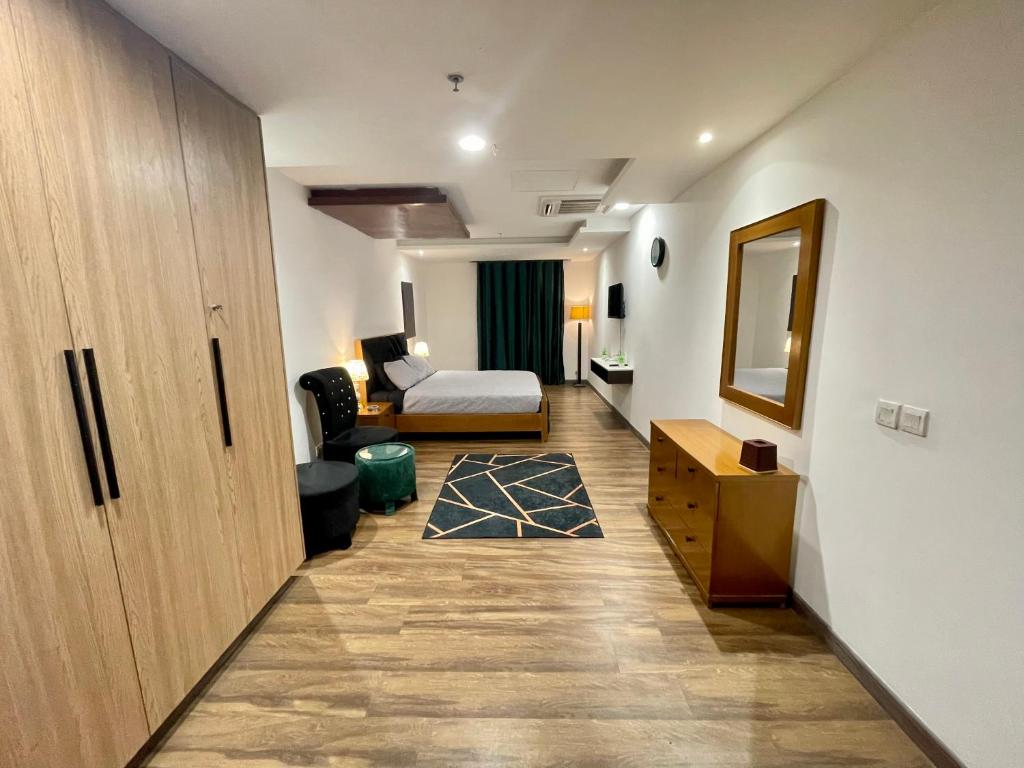 a hallway with a room with a bed and a desk at AirReside Hotel Apartments Gold Crest in Lahore
